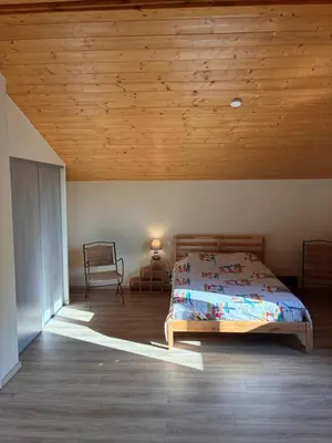 a bedroom with a bed and a wooden ceiling at Au doux paillis soleil couchant in Le Thor