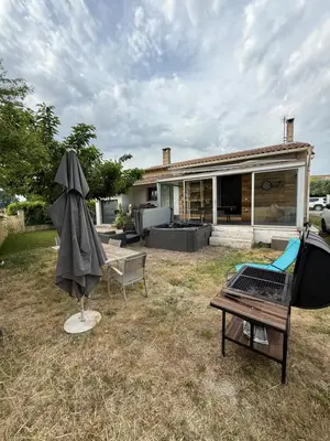 a backyard with a house with an umbrella and a table at La Tobynette in LʼIsle-sur-la-Sorgue