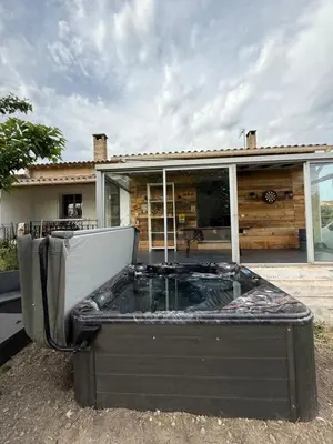 a hot tub sitting in front of a house at La Tobynette in LʼIsle-sur-la-Sorgue