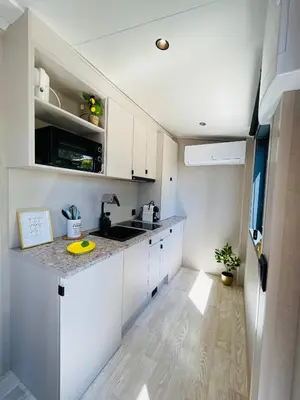 a kitchen with white cabinets and a counter top at Tiny Aix - Maison Odonata in Aix-en-Provence