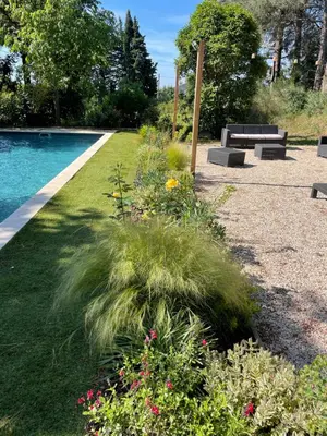 a garden with benches and flowers next to a pool at Tiny Aix - Maison Odonata in Aix-en-Provence