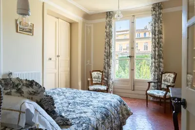 a bedroom with a bed and chairs and a window at Cardinale 4 rooms in Aix-en-Provence