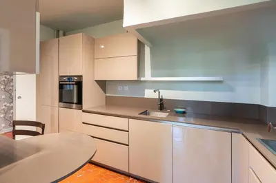 a kitchen with white cabinets and a table at Cardinale 4 rooms in Aix-en-Provence