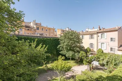 a view of a garden with buildings in the background at Cardinale 4 rooms in Aix-en-Provence