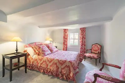 a bedroom with a large bed and a chair at Cardinale 4 rooms in Aix-en-Provence