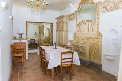 a dining room with a table and chairs and a mirror at Château vert in Cavaillon