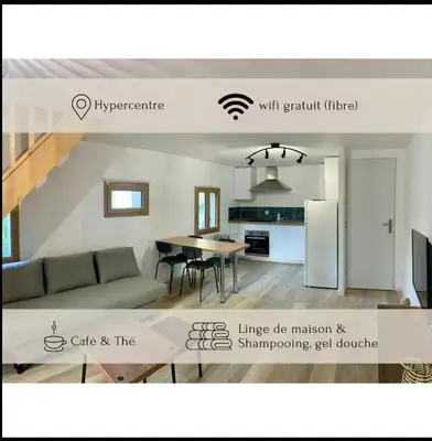 a kitchen and a living room with a couch and a table at La Rêverie in Le Thor