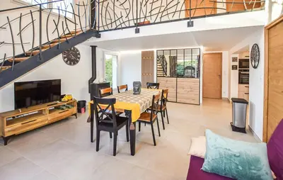 a dining room with a table and chairs and a tv at Tranquil Cottage With Views Of Mont Ventoux in Les Gaps