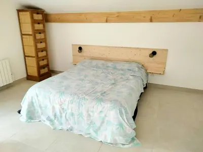 a bedroom with a bed with a wooden headboard at Tranquil Cottage With Views Of Mont Ventoux in Les Gaps