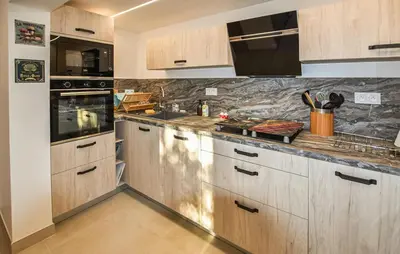 a kitchen with wooden cabinets and a counter top at Tranquil Cottage With Views Of Mont Ventoux in Les Gaps