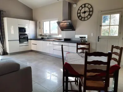 a kitchen with a table and a clock on the wall at Maison en Provence in Jouques
