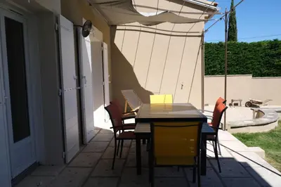 a table and chairs on a patio with an umbrella at Villa overlooking the Alpilles Saint Remy de Provence LS1-454 in Saint-Rémy-de-Provence