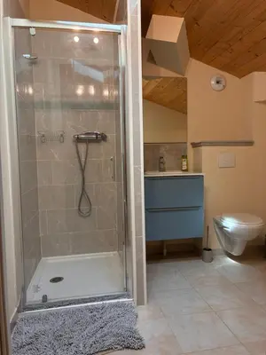 a shower with a glass door in a bathroom at Au doux paillis Sorgue in Le Thor