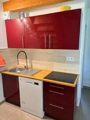 a kitchen with red cabinets and a sink at Au doux paillis Sorgue in Le Thor