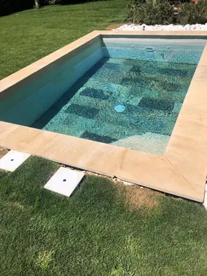a swimming pool with a wooden border in the grass at Quiet house in provence in Lauris