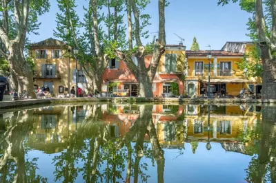 a reflection of buildings in a body of water at Quiet house in provence in Lauris