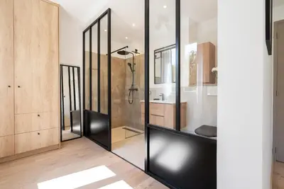 a bathroom with black glass walls and a shower at La Note Bleue Luberon in Maubec