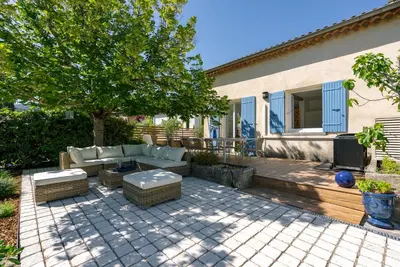 a patio with a couch and a table and a tv at La Note Bleue Luberon in Maubec