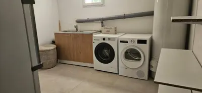 a laundry room with a washing machine and a sink at La Note Bleue Luberon in Maubec