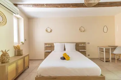 a bedroom with a large bed with a yellow towel on it at Le Lavandin - 3 to 4 beds - Hypercentre - Wifi in Apt