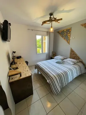 a bedroom with a bed and a desk in it at Maison de vacances in Le Thor