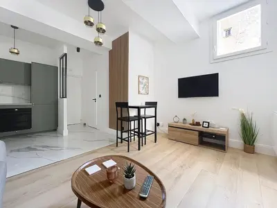 a white living room with a table and a tv at Côté Palmier - Luxurious 2-room - Center-by PauseAixoise in Aix-en-Provence