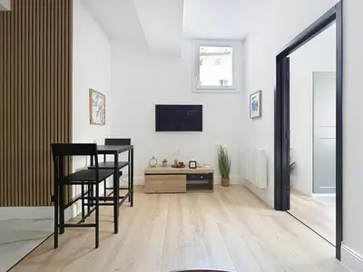 a living room with a table and chairs and a tv at Côté Palmier - Luxurious 2-room - Center-by PauseAixoise in Aix-en-Provence