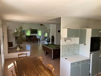 a kitchen and living room with a table and a pool table at Grande maison avec piscine in Aix-en-Provence