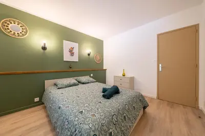 a bedroom with a bed and a green wall at Maison proche Avignon Clim Terrasse wifi 4pers in Jonquerettes
