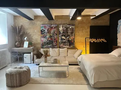 a bedroom with a bed and a couch and a table at La Suite 4 Dauphins- Aix en Provence in Aix-en-Provence