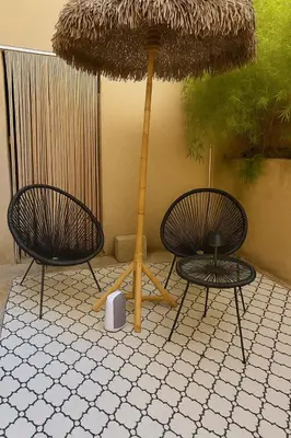 two chairs and an umbrella on a tiled floor at La Suite 4 Dauphins- Aix en Provence in Aix-en-Provence