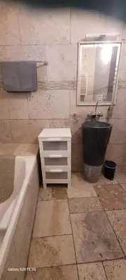 a bathroom with a tub and a sink and a mirror at Maison conviviale avec jardin à Revest-des-Brousses in Vachères