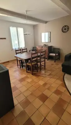 a living room with a wooden table and chairs at Maison conviviale avec jardin à Revest-des-Brousses in Vachères