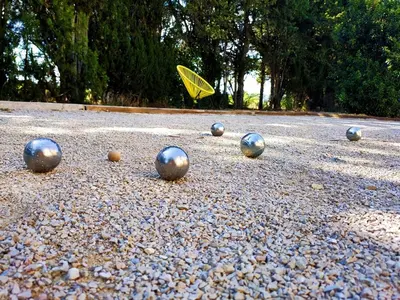 a group of balls on the ground with an umbrella at Ville au calme en Provence, piscine privée, spa jeux, proche Ventoux in Carpentras