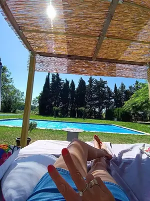 a woman laying on a bed in front of a pool at Ville au calme en Provence, piscine privée, spa jeux, proche Ventoux in Carpentras