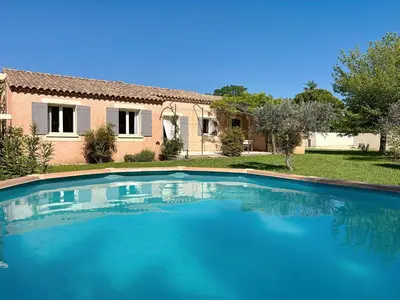 a large blue swimming pool in front of a house at Casa du Luberon in Maubec
