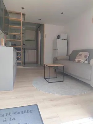 a living room with a couch and a table at Mayka in LʼIsle-sur-la-Sorgue