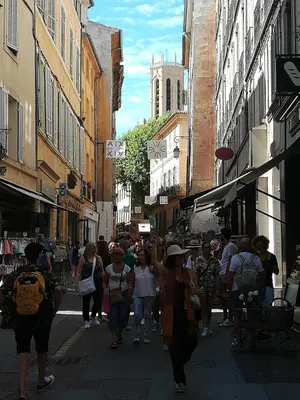 a crowd of people walking down a busy city street at Charmant studio centre historique Aix in Aix-en-Provence