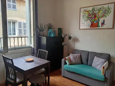 a living room with a couch and a table at Charmant studio centre historique Aix in Aix-en-Provence