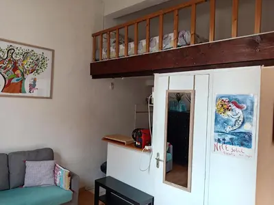 a living room with a couch and a staircase at Charmant studio centre historique Aix in Aix-en-Provence
