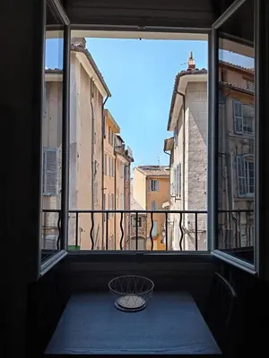 a window with a view of a city from a balcony at Charmant studio centre historique Aix in Aix-en-Provence