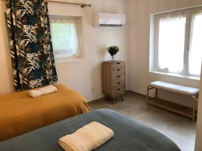a bedroom with two beds and a window at Gîte 6 pers en Provence avec grande piscine partagée avec 2nd gîte - 6 pers house in Provence with a large swimming pool to be shared with a 2nd house in Cornillon-Confoux