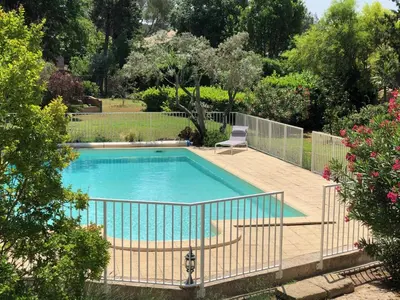 a swimming pool with a chair in a yard at Gîte 6 pers en Provence avec grande piscine partagée avec 2nd gîte - 6 pers house in Provence with a large swimming pool to be shared with a 2nd house in Cornillon-Confoux