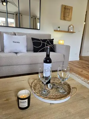 a table with a bottle of wine and two glasses at le logis des roues in LʼIsle-sur-la-Sorgue