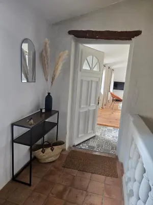a hallway with a white door and aoyer with a table at le logis des roues in LʼIsle-sur-la-Sorgue