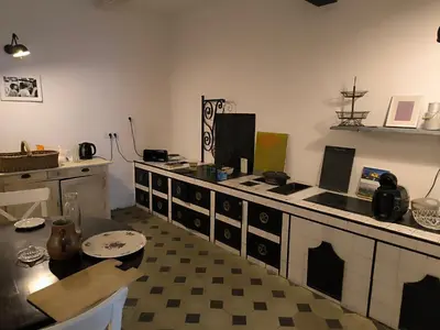 a kitchen with a stove and a table in it at Les Chambres De Charlotte in Cucuron