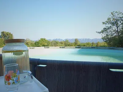 a table with a vase and a glass on a balcony at Mas Bruneau in Noves