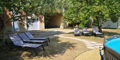 three blue chairs sitting next to a swimming pool at Mas Bruneau in Noves