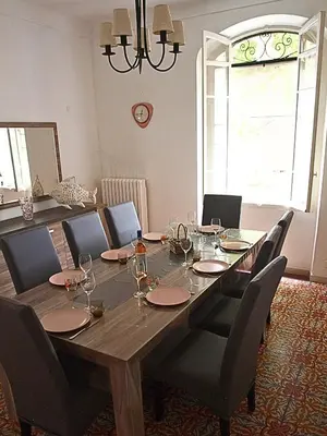 a large wooden table with chairs and a large window at Mas Bruneau in Noves