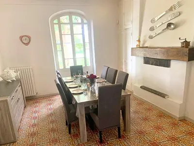 a dining room with a table with chairs and a fireplace at Mas Bruneau in Noves
